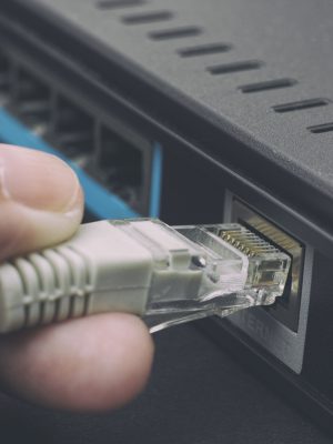 Person plugging in cable to wireless router. Close up.