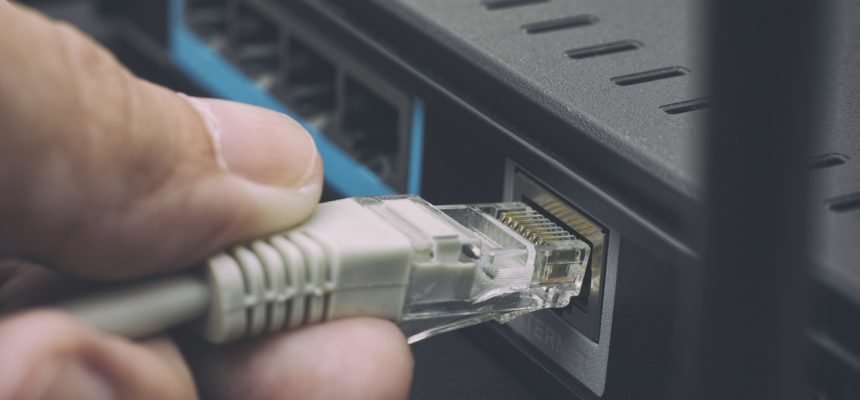 Person plugging in cable to wireless router. Close up.